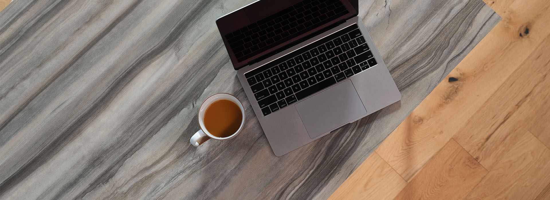 Close-up of marbled Formica laminate desk with laptop and coffee